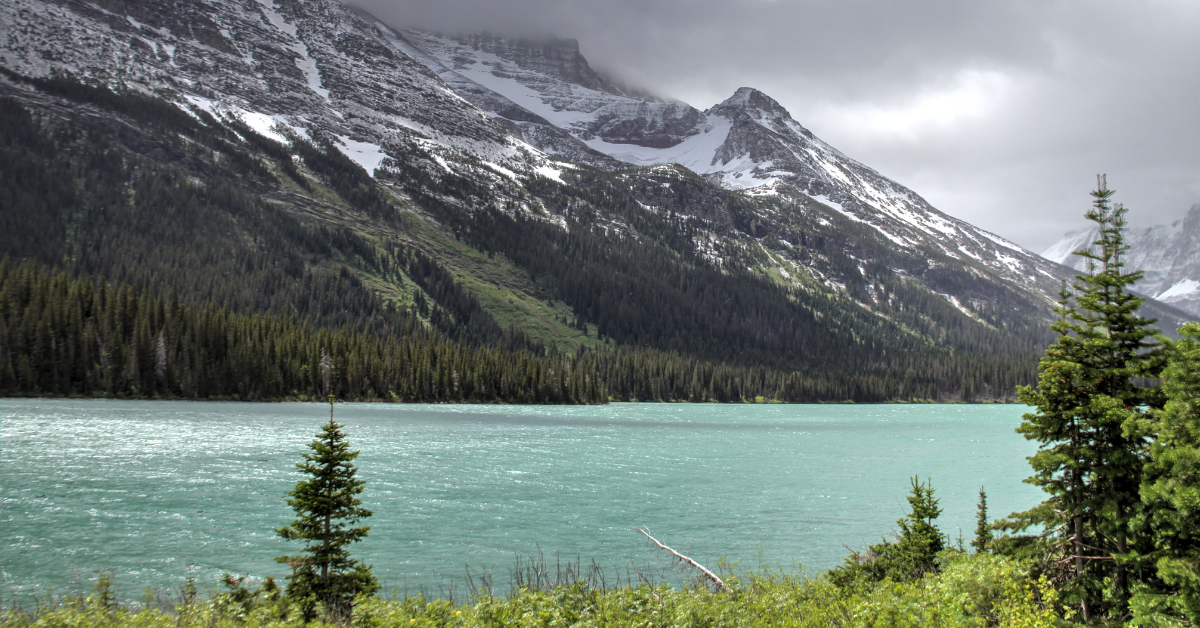 Rainy day scenery in Glacier National Park with turquoise lake and mountain peaks